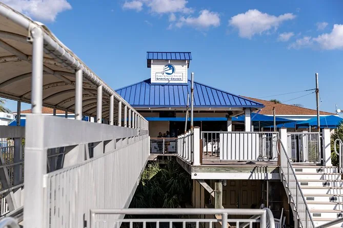 A covered harbor-side boarding building with ramps and stairs down to the water